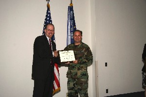 Technical Sgt. Joel Tanner, USAF (r), chapter officer, receives the Special Service to Education plaque from Dave Judson, chapter president, at the September meeting.